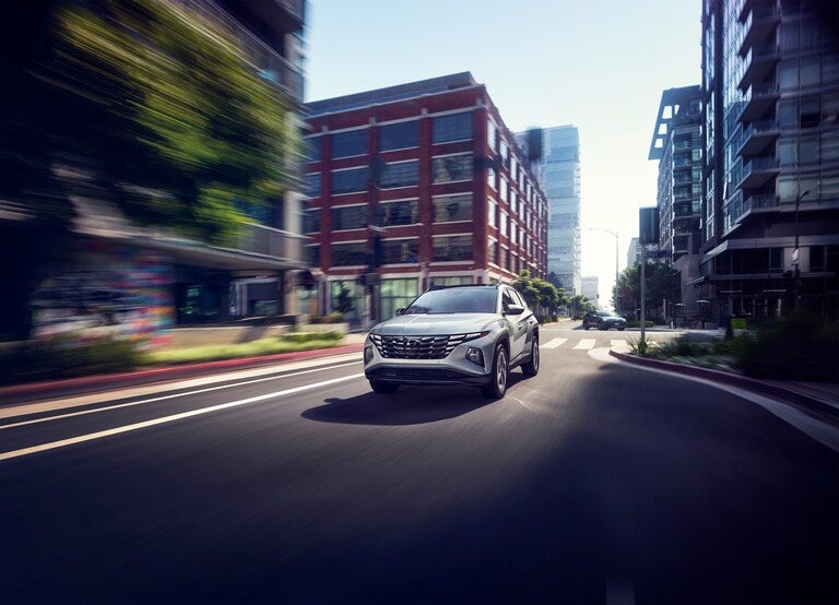Three quarter front view of Hyundai SUV cruising through the city