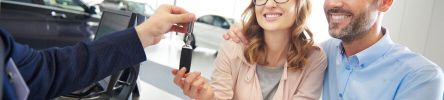 A happy couple being handed the keys to their Hyundai vehicle