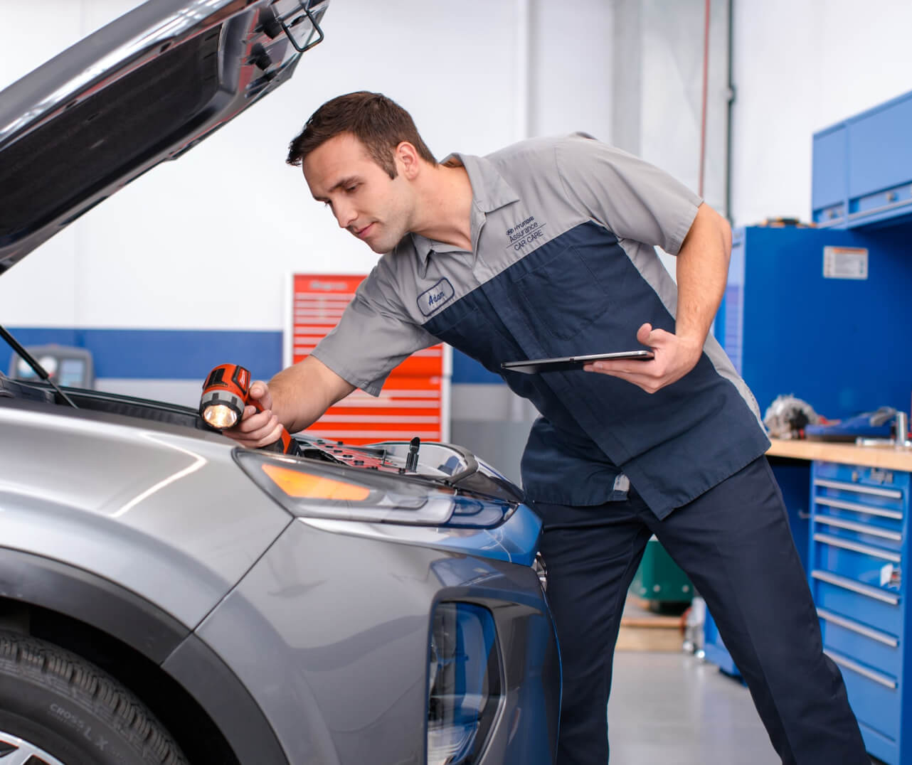 A Hyundai certified technician inspects under the hood of a Hyundai car.