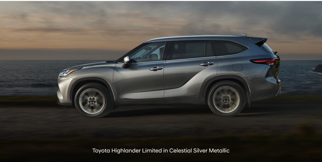 Toyota Highlander Limited in Celestial Silver Metallic with rear spoiler on coastal highway.